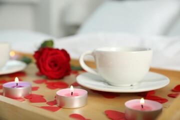 Sticker - Wooden tray with burning candles, rose, cup of drink and red paper hearts on bed indoors, closeup