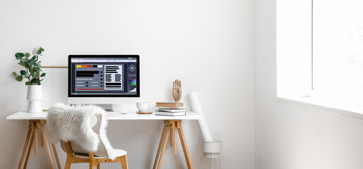 Wall Mural - Modern workplace with computer and eucalyptus in vase near light wall