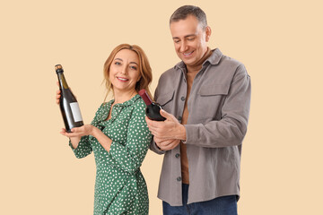 Canvas Print - Mature couple with bottles of wine on beige background