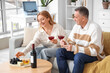© Pixel-Shot - Mature couple with glasses of wine at home