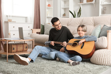 Sticker - Private music teacher giving guitar lessons to little boy in living room