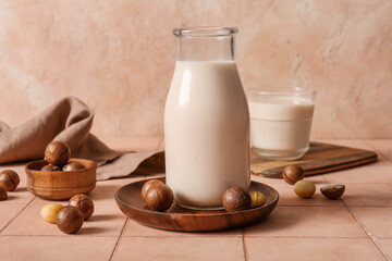 Canvas Print - Bottle and glass of fresh macadamia milk on beige tile table