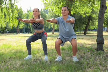 Poster - Sporty young woman training with personal trainer in park