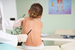 © Pixel-Shot - Female osteopath working with little patient on couch in clinic, back view
