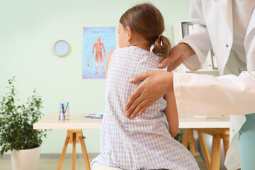 Wall Mural - Female osteopath working with little patient in clinic, back view