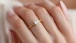 © Wimstock - Elegant diamond engagement ring on female hand against white background