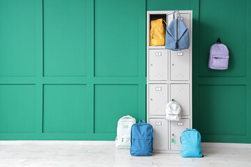 Wall Mural - Locker with school backpacks near green wall