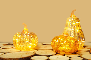 Wall Mural - Glowing pumpkins on wooden table against green background