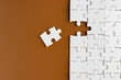 © Hasim Ramle - Top view of unfinished jigsaw puzzle on chocolate brown background. Business concept.