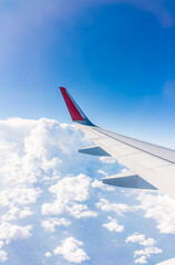 Wall Mural - View from the airplane window at a beautiful cloudy sky and the airplane wing