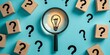 © keks20034 - A glowing light bulb under a magnifying glass among cubes with question marks symbolizes thinking and ideas