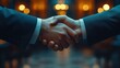 © Attasit - A business deal being closed with a handshake, signifying the successful negotiation between two corporate entities.