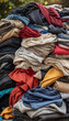 © Prateek - A very Large pile of old used clothing, clothes and textiles in an outdoor environment. Fast fashion and clothing recycling, textile cloth or clothing waste concept, waste cloths donation