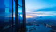 © xy - Successful businessman standing in office looking through window at big city buildings, planning new project in the evening