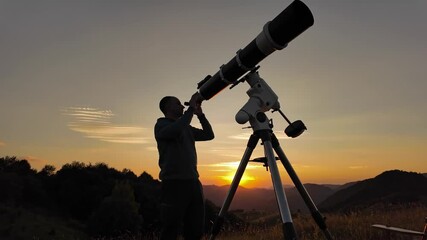 Wall Mural - Amateur astronomer looking at the evening skies, observing planets, stars, Moon and other celestial objects with a telescope just before sun down.	
