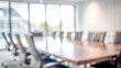 © Mari - An out-of-focus image of a corporate meeting room with a large table and chairs, symbolizing collaborative discussions and teamwork.