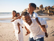 © Lumeez23/peopleimages.com - Piggyback, playing and black family at beach for fun on tropical vacation, travel or getaway. Smile, bonding and African children with parents by ocean or sea on holiday, adventure or weekend trip.