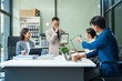 © Phushutter - In a boardroom, an Asian team meets at a desk, presenting financial terms and strategies. Executives and employees collaborate, sharing ideas and work guidelines for success during an annual meeting.