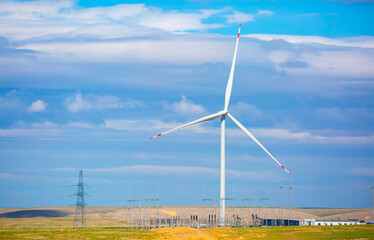 Fleet of power generators in motion. The blades of the wind farm rotate against the sky. The concept of extracting electricity from renewable sources. Wind turbine to generate electricity.