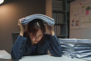 Wall Mural - Asian businesswoman is stressed and bored from working long hours on laptop. Tired young woman with a headache at the office Feeling sick at work Office syndrome concept.