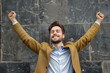 © FutureStock - Portrait of a cheerful businessman celebrating his success over gray stone blocks background
