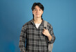 © 1112000 - Portrait of Asian male student posing on blue background