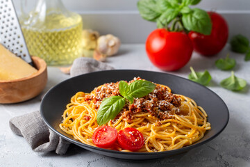 Pasta spaghetti bolognese with minced beef sauce, tomatoes, parmesan cheese and fresh basil in a plate