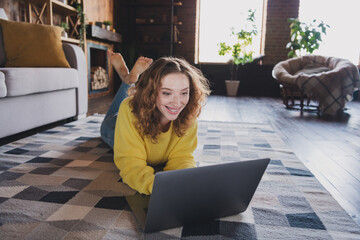 Poster - Full length photo of lovely young lady lying floor netbook dressed yellow sweater spend pastime spacious house indoors room