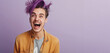 © Bonsales - Nonbinary person with vibrant purple hair smiling broadly and wearing a yellow jacket over a gray shirt against a light purple background. The expression on their face is one of excitement and joy.