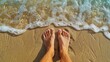 © kinara art design - Woman's bare feet standing on the sand at the edge of the ocean waves.
