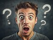 © Mikki Orso - Close up portrait of a young man looking shocked with question marks floating around his head
