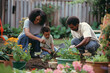 © MobiWall - A peaceful scene of a family gardening together in their backyard. They are planting flowers, watering plants, and enjoying the fresh air. The parents are teaching the children about gardening