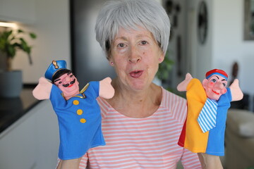 Senior teacher holding some cute puppets 