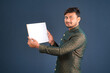 © Dip Photography - A happy young man is holding and displaying a signboard or placard on a dark background.