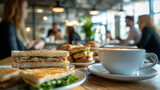 Enjoying a casual lunch with sandwiches and coffee in a bustling café filled with friends and conversations in the afternoon light