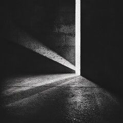 Aufkleber - A narrow, precise beam of light pierces through the darkness, illuminating part of a concrete floor, creating dramatic contrasts and a sense of mystery and solitude.