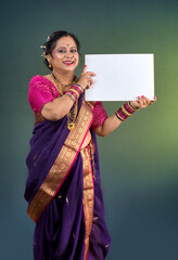 Cheerful traditional Indian woman wearing saree holding a blank billboard