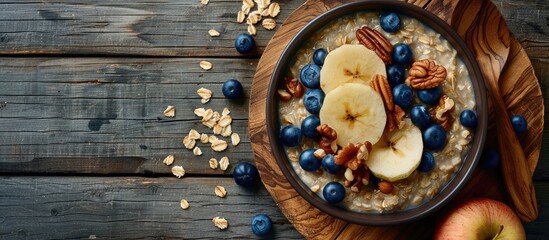 Wall Mural - Oatmeal with blueberries apple and nuts A bowl of oatmeal porridge on wooden boards Healthy breakfast idea Top view Copy space