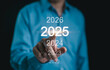 © Supatman - Happy New Year 2025, Businessman points toward the year 2025 on a digital timeline, symbolizing future business goals, planning, and strategic growth initiatives. Company strategy, Business target,
