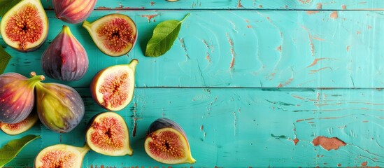 Poster - Top view of fresh figs on a turquoise wooden table background Healthy snack and food. Copy space image. Place for adding text and design