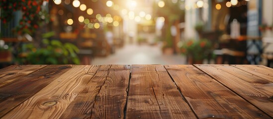 Poster - Focused empty brown wooden table with a blurred coffee shop or restaurant background featuring bokeh effects ideal for your photomontage or product display. Copy space image