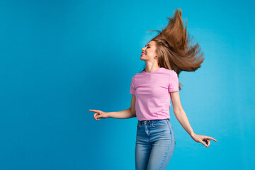 Poster - Photo portrait of pretty young girl dance fluttering hair wear trendy pink outfit isolated on blue color background