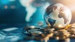 © PrusarooYakk - Close-up of a glass globe on coin stacks, with a blurred map in the background, representing global finance, investment, and economy concepts.