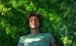 © Patrick - Man relaxing on grass in sunlit nature, arms behind head, peaceful outdoor moment