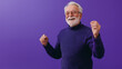 © Andres Mejia - Happy senior man wearing purple sweater is dancing on purple background