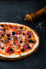 Wall Mural - Pizza with sausage, cheese, sweet pepper, olives, jalapeno pepper, red onion on thin dough.