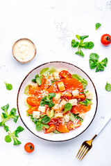 Wall Mural - Delicious salad with salmon, iceberg lettuce, croutons, grated parmesan cheese and caesar dressing. White background, top view