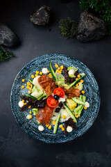 Canvas Print - Lunch salad with fried suluguni cheese, sun-dried tomatoes, corn, cucumbers, lettuce and sauce.