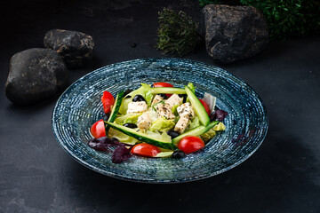 Wall Mural - Lunch Greek salad of fresh cucumber, cherry tomatoes, lettuce, feta cheese, olives and basil.