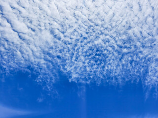 a serene sky with fluffy, cotton-like clouds scattered across a deep blue backdrop. perfect for natu